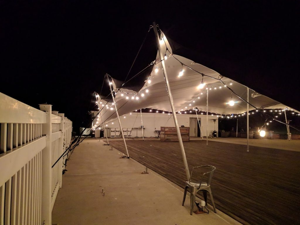 stanley_wedding_canopy_open_with_lighting_and_dancefloor Wedding tent at night with string lights and dance floor