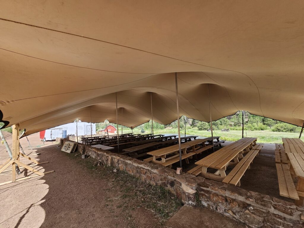 West Creek Tent Rental2 Picnic tables under stretch tent
